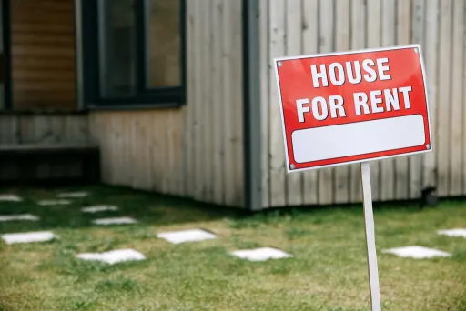 For rent sign near a wooden house